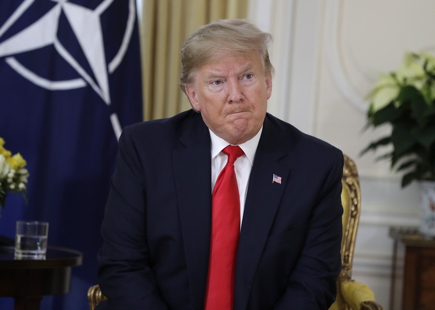 U.S. President Donald Trump grimaces during a meeting with NATO Secretary General, Jens Stoltenberg at Winfield House in London, Tuesday, Dec. 3, 2019. US President Donald Trump will join other NATO h ...