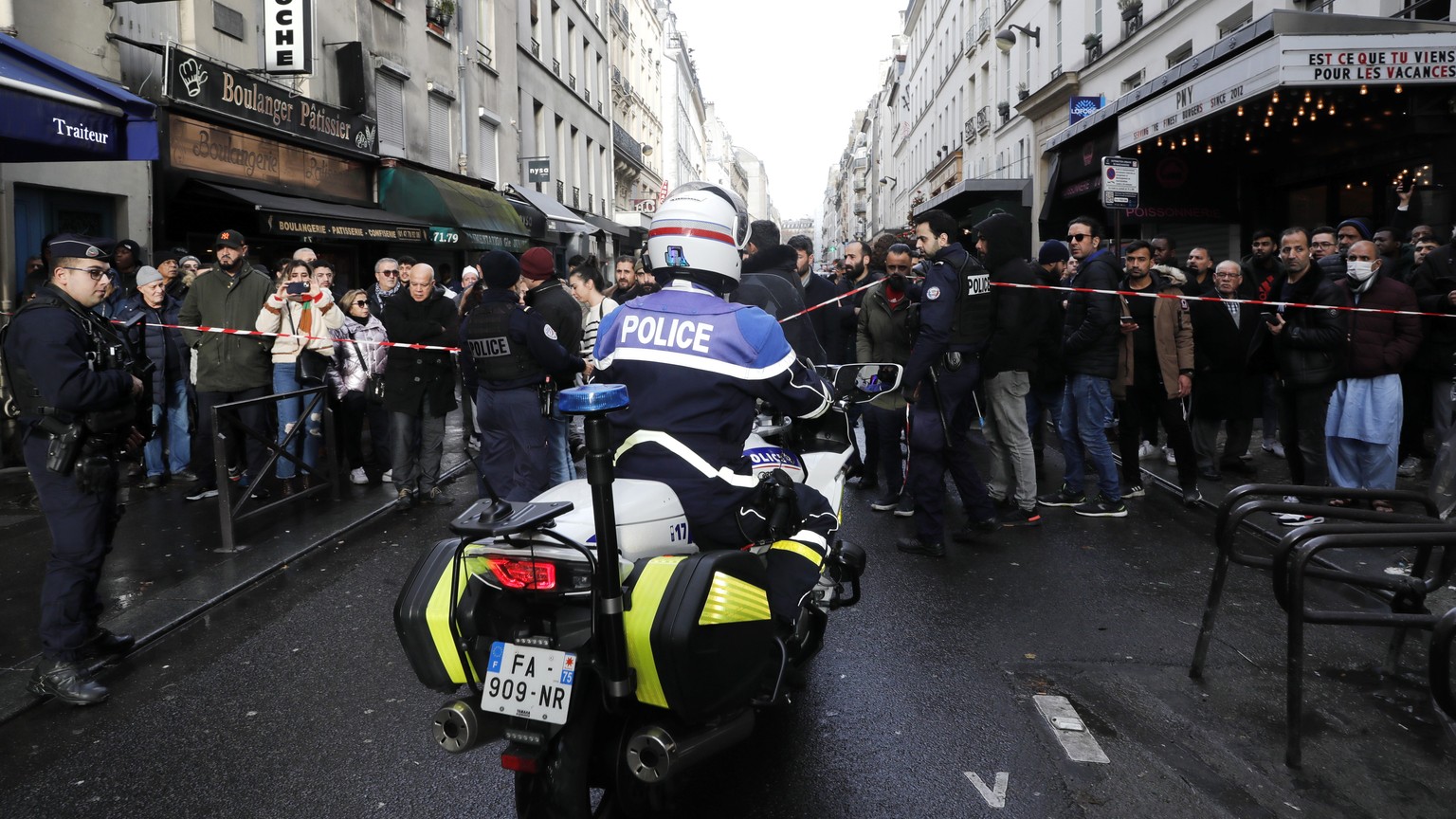 epa10377112 Local residents and onlookers gather following a shooting incident on &#039;Rue d&#039;Enghien&#039;, near a Kurdish cultural centre in Paris, France, 23 December 2022. The Paris Police Pr ...