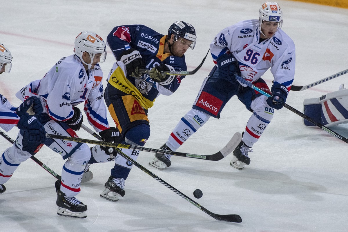 Oscar Lindberg, mitte, von Zug im Spiel gegen Tim Berni, rechts, vom ZSC beim Eishockey Meisterschaftsspiel in der Qualifikation der National League zwischen dem EV Zug und den ZSC Lions vom Samstag,  ...