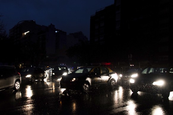 Cars drive through an unlit street during a blackout in Buenos Aires, Argentina, Sunday, June 16, 2019. A massive blackout left tens of millions of people without electricity in Argentina, Uruguay and ...