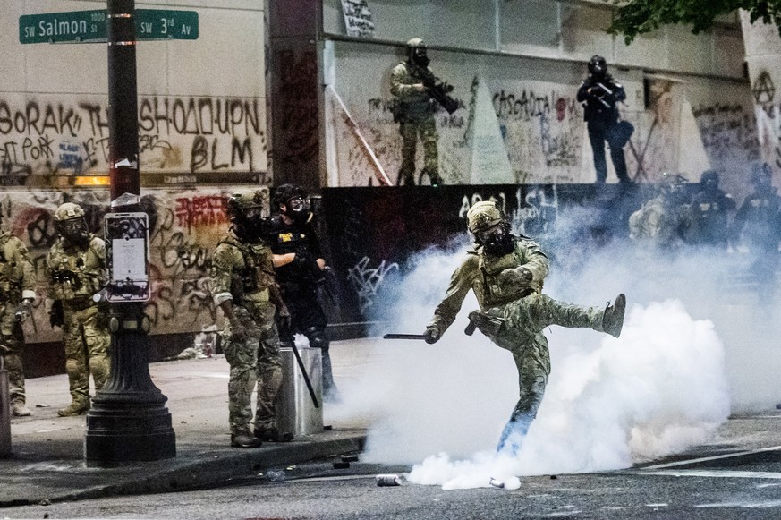 Federal officers use crowd control munitions to disperse Black Lives Matter protesters outside the Mark O. Hatfield United States Courthouse on Tuesday, July 21, 2020, in Portland, Ore. (AP Photo/Noah ...