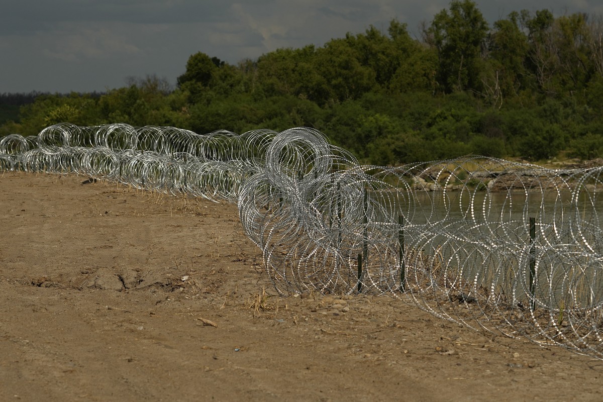 Concertina wire lines the banks of the Rio Grande on the Pecan farm of Hugo and Magali Urbina, near Eagle Pass, Texas, Monday, July 7, 2023. Texas Republican Gov. Greg Abbott has escalated measures to ...