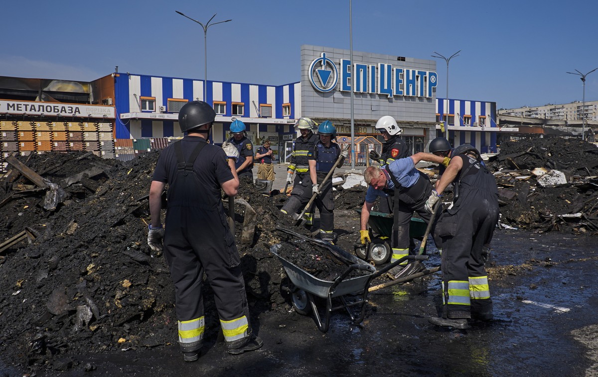 epa11371742 Communal workers clear debris following yesterday's shelling of the hypermarket in Kharkiv, Ukraine, 26 May 2024 amid the Russian invasion. Russian troops shelled by two glide-bombs t ...