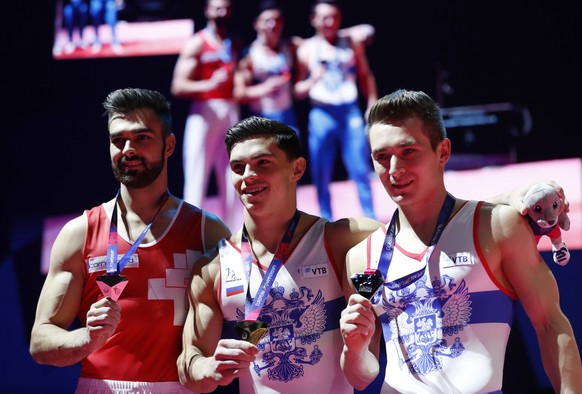 Artur Dalaloyan of Russia, center, celebrates with the gold medal after placing first on the parallel bars during the men&#039;s artistic gymnastics finals at the European Championships in Glasgow, Sc ...