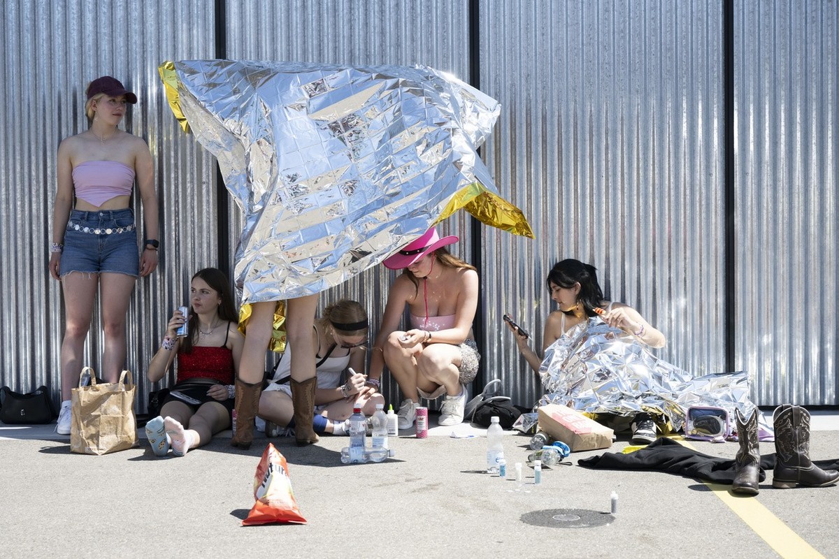 Fans, also known as 'Swifties', wait to attend the concert of US singer and songwriter Taylor Swift as part of her 'The Eras Tour' in front of the Letzigrund Stadium in Zurich, Swi ...