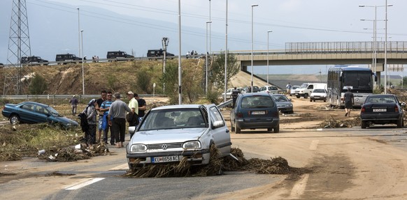 epa05461008 People between damaged vehicles on the ring road around Skopje, The Former Yugoslav Republic of Macedonia on 07 August 2016. At least 15 people have died in a rain storm that hit the Maced ...