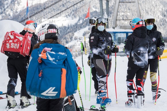 epa08879576 Skiers wear face masks on the opening day of the Airolo ski area in the Swiss Alps during the coronavirus disease (COVID-19) pandemic, in Airolo, Switzerland, 12 December 2020. Winter spor ...