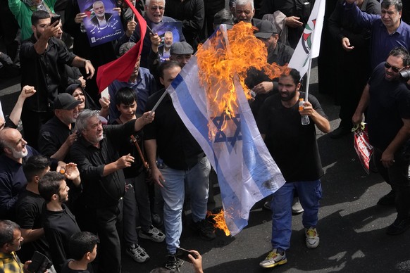 Iranians burn a representation of the Israeli flag during the funeral ceremony of Hamas leader Ismail Haniyeh and his bodyguard who were killed in an assassination blamed on Israel on Wednesday, at En ...
