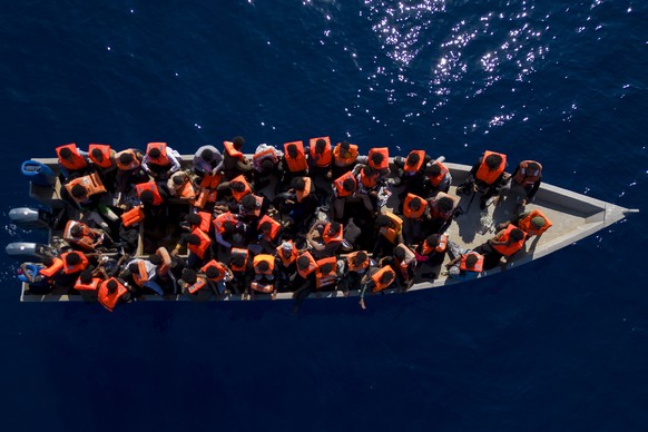 FILE - Migrants from Eritrea, Libya and Sudan sail in a wooden boat before being assisted by aid workers from Spanish NGO Open Arms, in the Mediterranean Sea, about 30 miles north of Libya, Saturday, J...