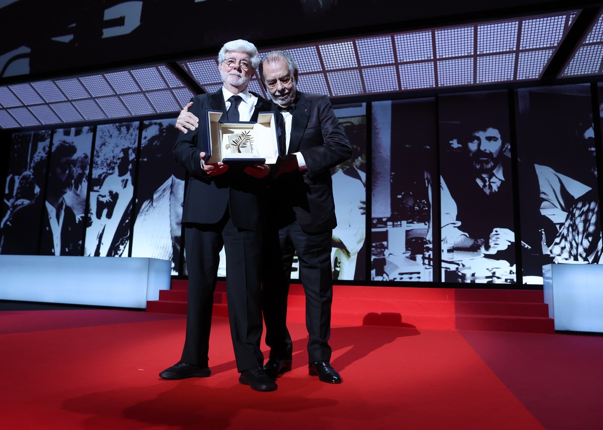 epa11369865 George Lucas (L) accepts the Honorary Palme D'Or Award from Francis Ford Coppola (R) during the closing and awards ceremony of the 77th annual Cannes Film Festival, in Cannes, France, ...