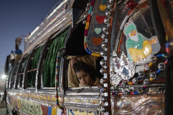 A girl looks out of a traditional bus in Islamabad, Pakistan, Thursday, Nov. 11, 2021. (AP Photo/Petros Giannakouris)