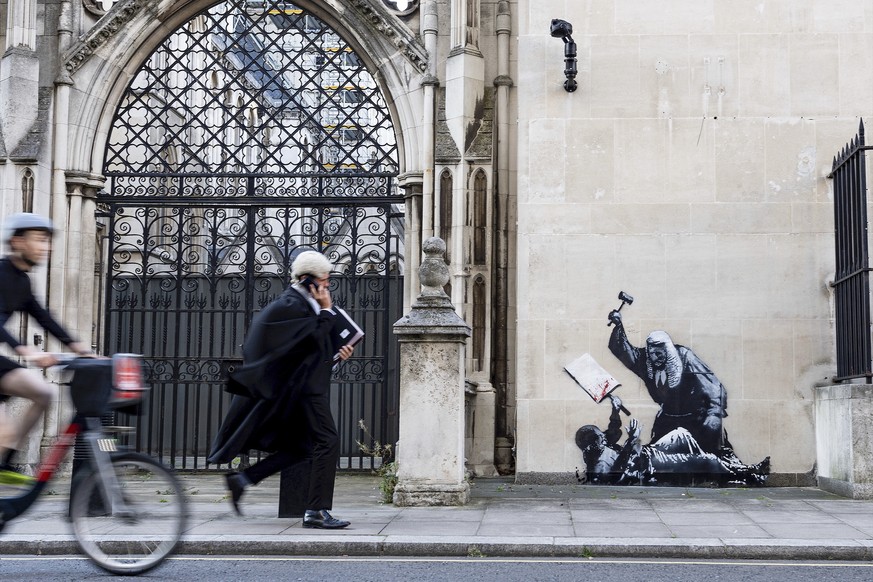 Undated photo released by Banksy of the new artwork by the artist which portrays a judge beating a protester with a gavel at the Royal Courts of Justice in London. (Banksy via AP)
Britain Banksy
