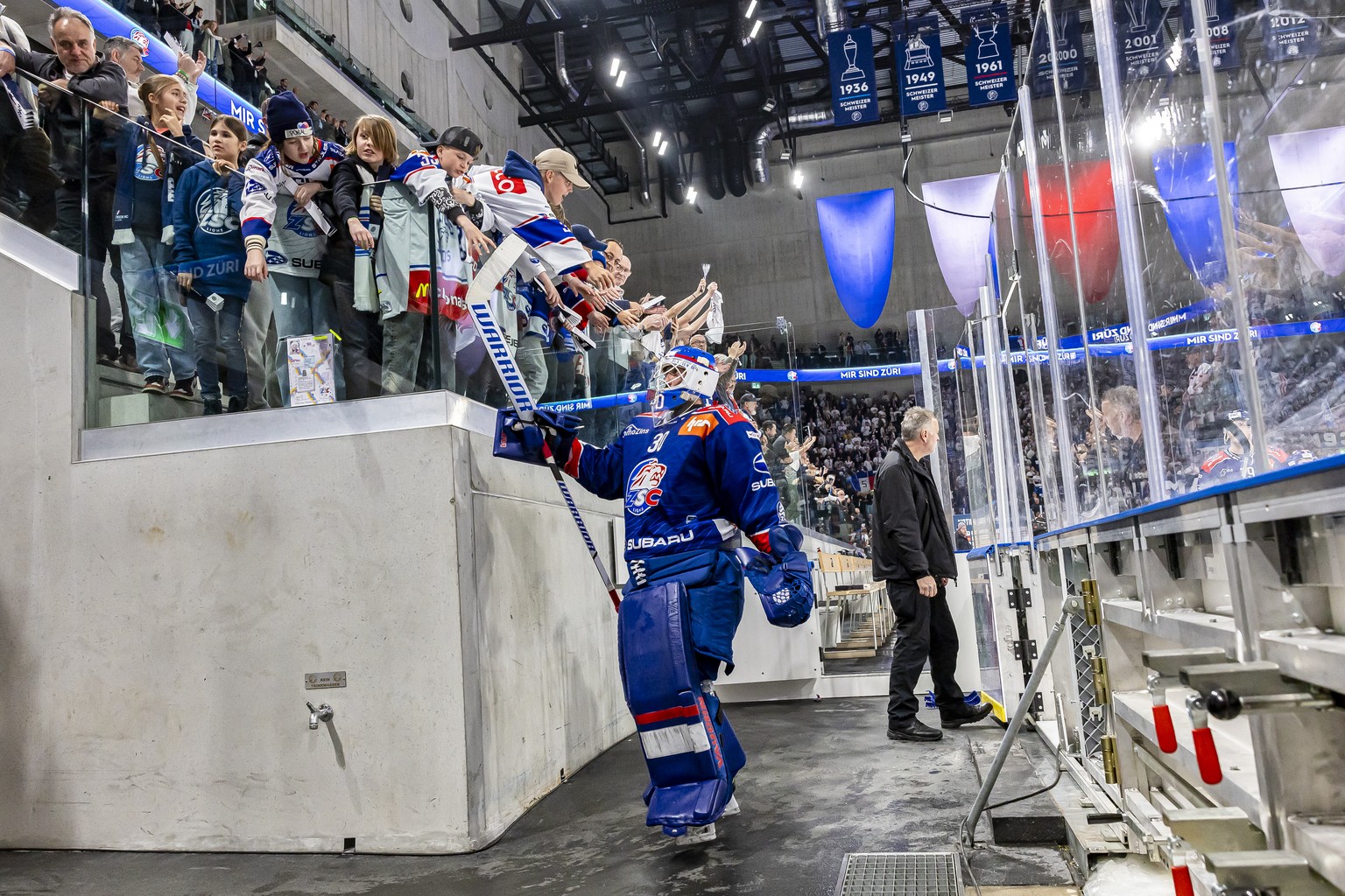 Torhueter Simon Hrubec (ZSC) feiert mit jungen Fans nach ihrem Sieg im fuenften Playoff Final Eishockeyspiel der National League zwischen den ZSC Lions und Lausanne HC, am Donnerstag, 25. April 2024 i ...