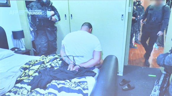 epa09254546 Australian Federal Police a deputy Commissioner Nigel Ryan displays an arrest during raids at a media briefing following a press conference by Prime Minister Scott Morrison in Sydney, Aust ...