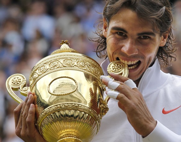 Rafael Nadal bites the trophy, after defeating Tomas Berdych in the men&#039;s singles final on the Centre Court at the All England Lawn Tennis Championships at Wimbledon, Sunday, July 4, 2010. (AP Ph ...