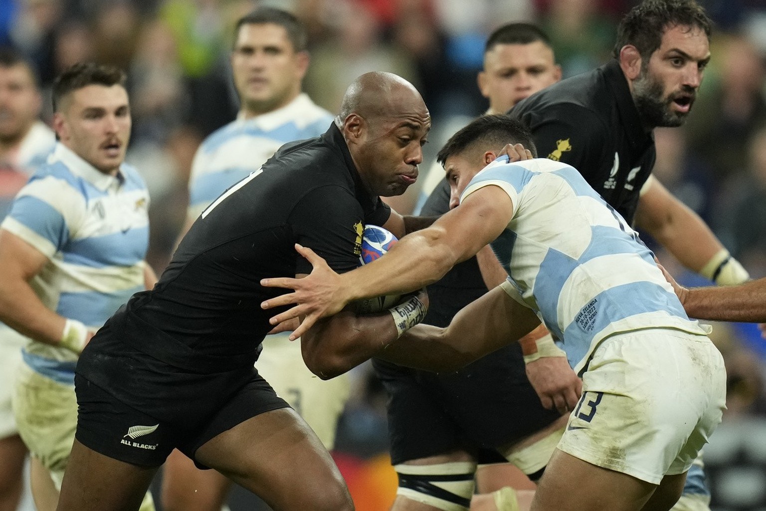 New Zealand&#039;s Mark Telea ,left, is grappled by Argentina&#039;s Lucio Cinti during the Rugby World Cup semifinal match between Argentina and New Zealand at the Stade de France in Saint-Denis, out ...