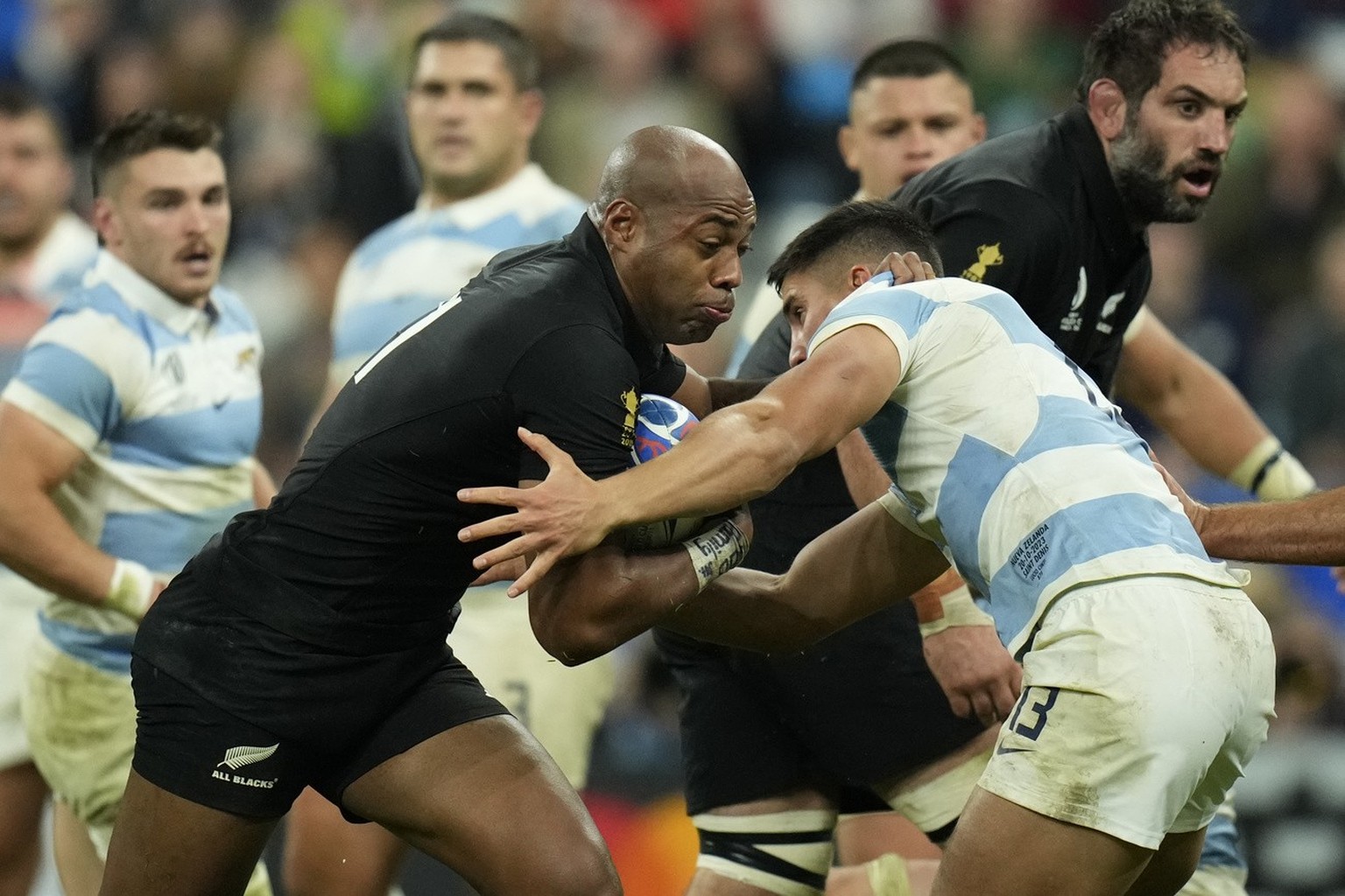 New Zealand's Mark Telea ,left, is grappled by Argentina's Lucio Cinti during the Rugby World Cup semifinal match between Argentina and New Zealand at the Stade de France in Saint-Denis, out ...