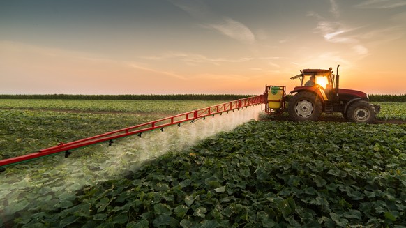 Traktor versprüht Pestizide.