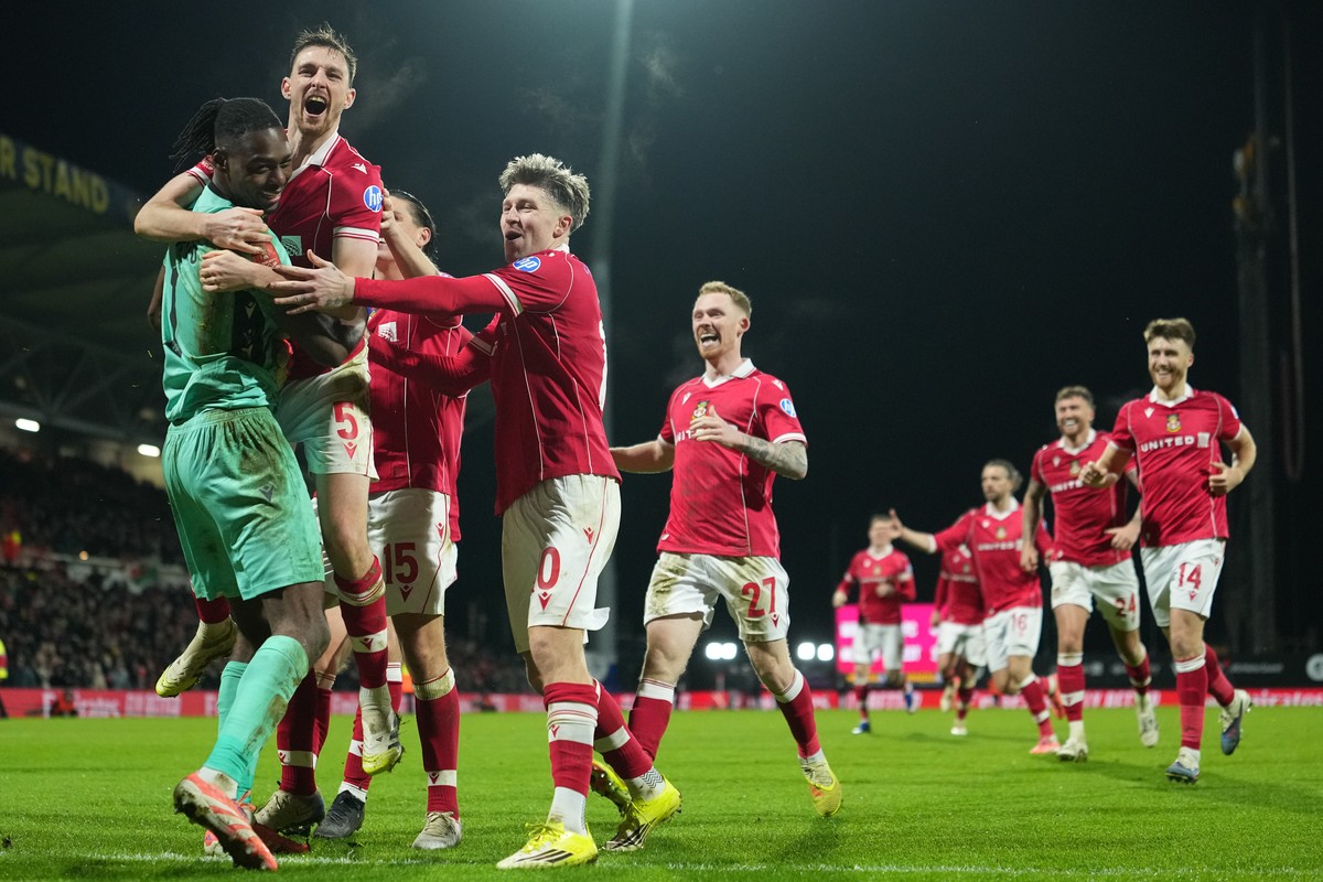 Wrexham's goalkeeper Arthur Okonkwo, left, celebrates with teammates after a penalty shootout at the end of the English FA Cup third round soccer match between Wrexham and Nottingham Forest in Wr ...