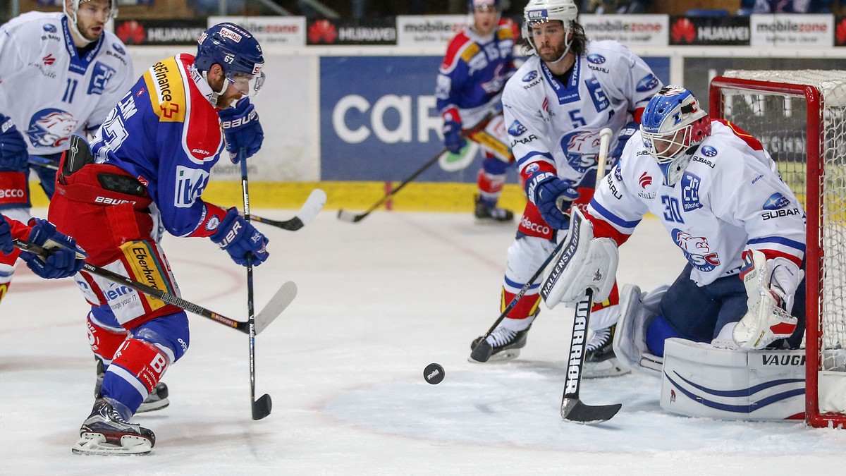 EHC Kloten Stuermer Romano Lemm, links, gegen ZSC Lions Torhueter Lukas Flueeler und Verteidiger Severin Blindenbacher, 2. von rechts, waehrend dem Eishockey-Meisterschaftsspiel der National League A  ...