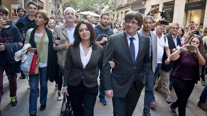 epa06295220 Catalan dismissed President, Carles Puigdemont (CR), and his wife, marcela Topor greets supporters as he leaves a restaurant in Vi square, Girona (Catalonia, northeastern Spain), 28 Octobe ...