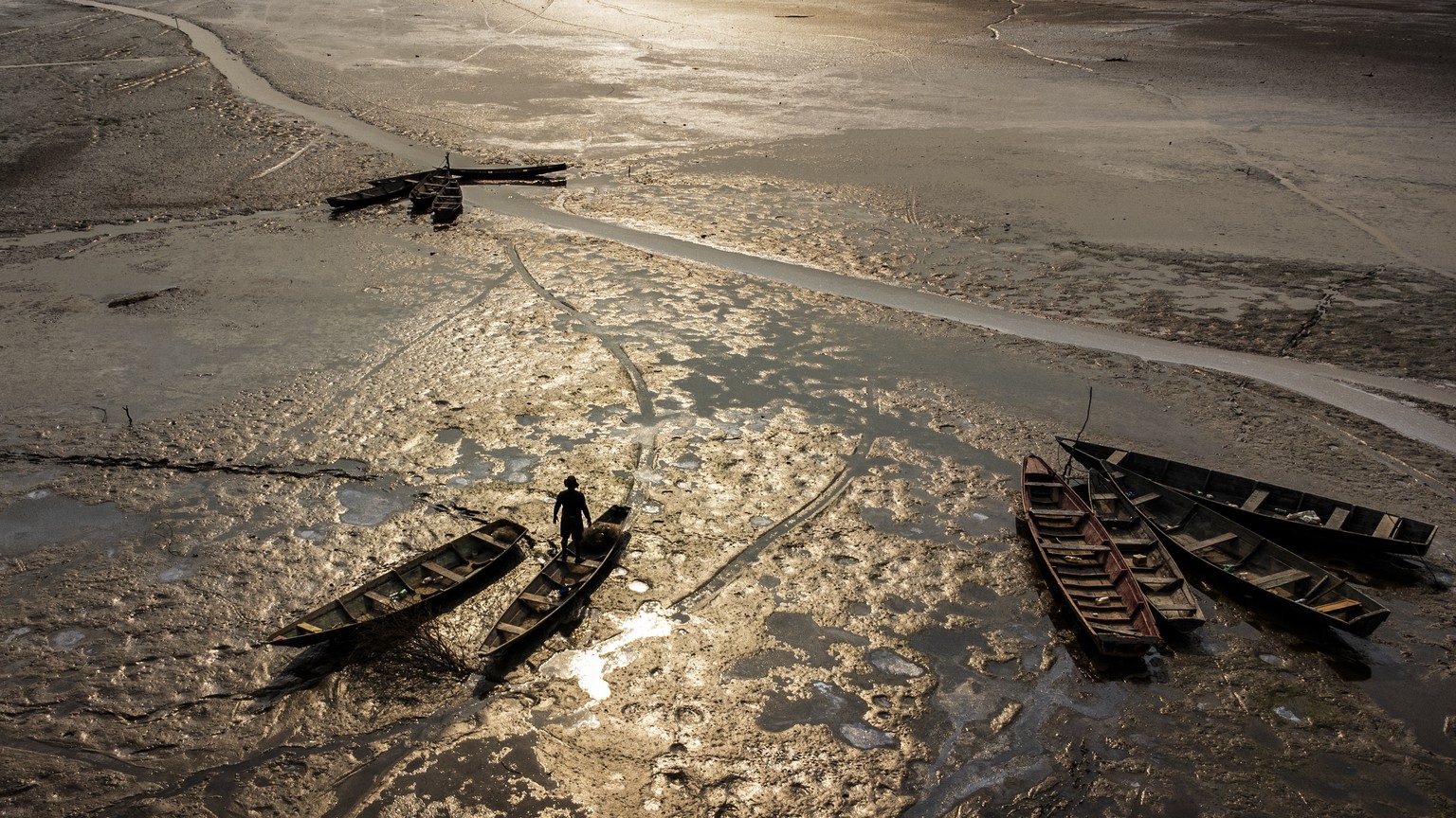 epa11606554 Aerial photograph showing a person in a stuck boat in Lago do Aleixo, Encontro das Aguas region, east of Manaus, Amazonas, Brazil, 15 September 2024. The riverside population of the metrop ...