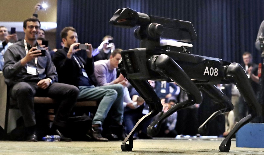 In this Thursday, May 24, 2018, photo, a Boston Dynamics SpotMini robot is walks through a conference room during a robotics summit in Boston. The secretive robotics firm Boston Dynamics and its found ...