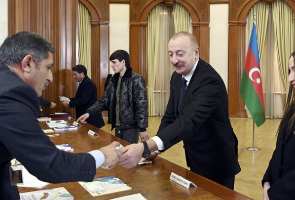 epa11134303 A handout photo made available by Azerbaijan President press-service shows Azerbaijan&#039;s President Ilham Aliyev (2-R) and his family members vote during extraordinary Presidential elec ...