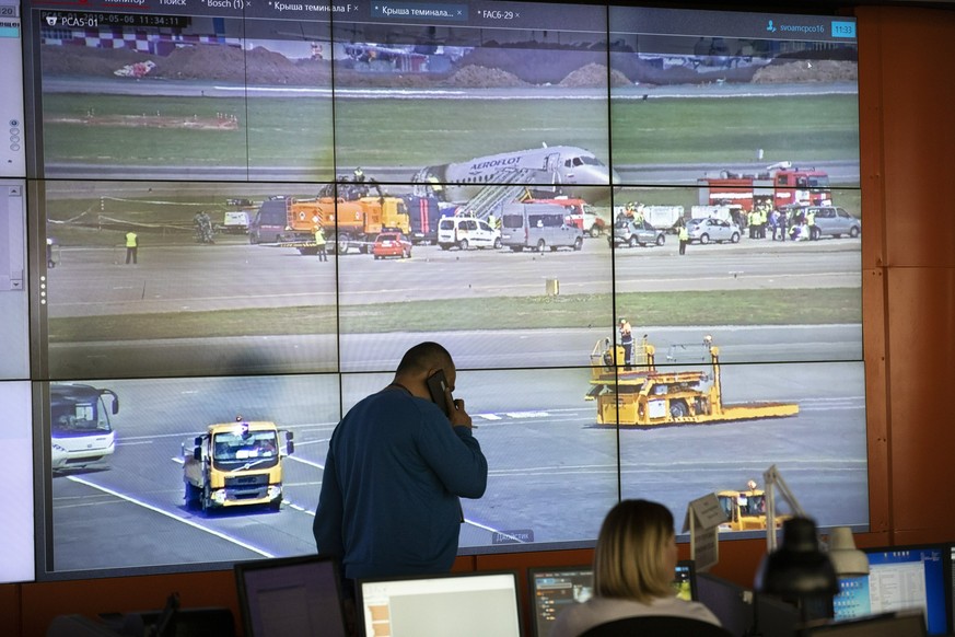 The scene of the Sukhoi SSJ100 aircraft of Aeroflot Airlines after an emergency landing is viewed on a big screen at a control room in Sheremetyevo airport, outside Moscow, Russia, Monday, May 6, 2019 ...