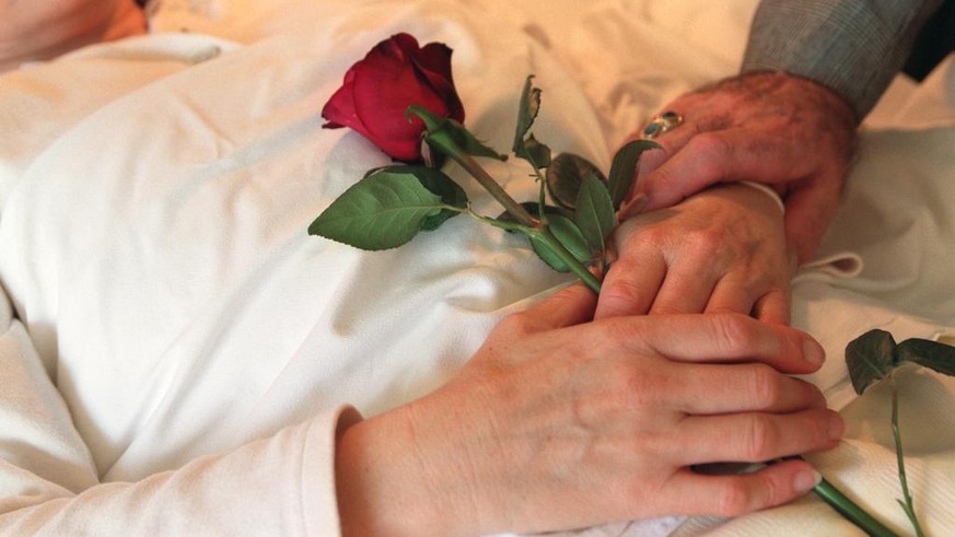 Themenbild zur Sterbehilfe, Euthanasie. Haende einer Patientin und eine Rose im Spital Uznach, gestellte Aufnahme vom 6. Dezember 2001. (KEYSTONE/Martin Ruetschi) : FILM]