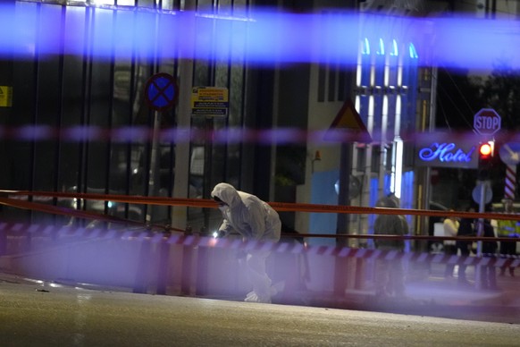Police investigators wearing coveralls inspect the site after a bomb explosion outside of the Hellenic Train offices the company that runs Greece&#039;s railway, the first building on the left, in Ath ...