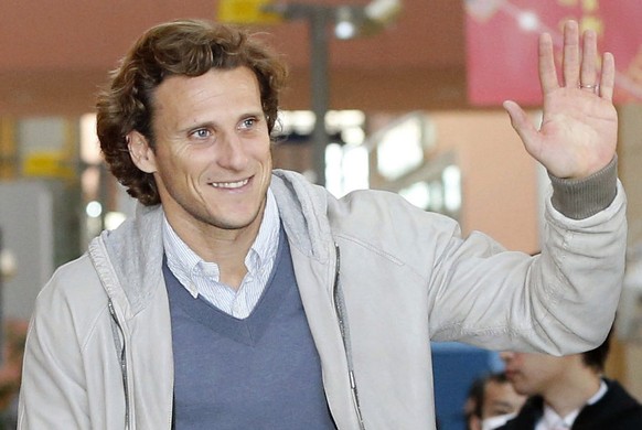 Uruguay striker Diego Forlan waves to supporters on his arrival at Kansai International Airport in Osaka, western Japan Wednesday, Feb. 12, 2014. Forlan will play for Cerezo Osaka in Japan. (AP Photo/ ...