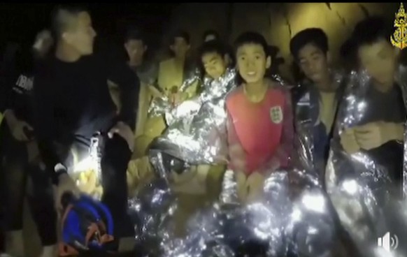 In this July 3, 2018, image taken from video provided by the Thai Navy Seal, Thai boys are with Navy SEALs inside the cave, Mae Sai, northern Thailand. With heavy rains forecast to worsen flooding in  ...