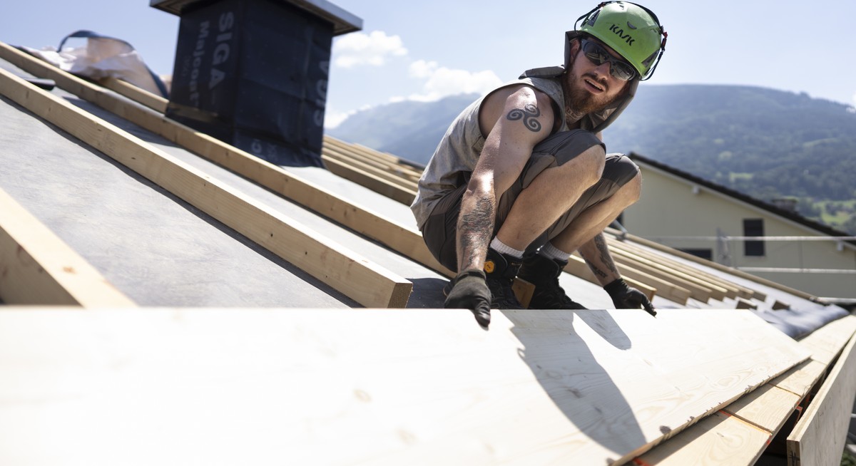 Ein Mitarbeiter der Greencover AG arbeitet an der Sanierung und Neuisolierung eines Daches bei grosser Hitze und starker Sonne, fotografiert am Mittwoch, 24. Juni 2026 in Mels (KEYSTONE/Gaetan Bally)