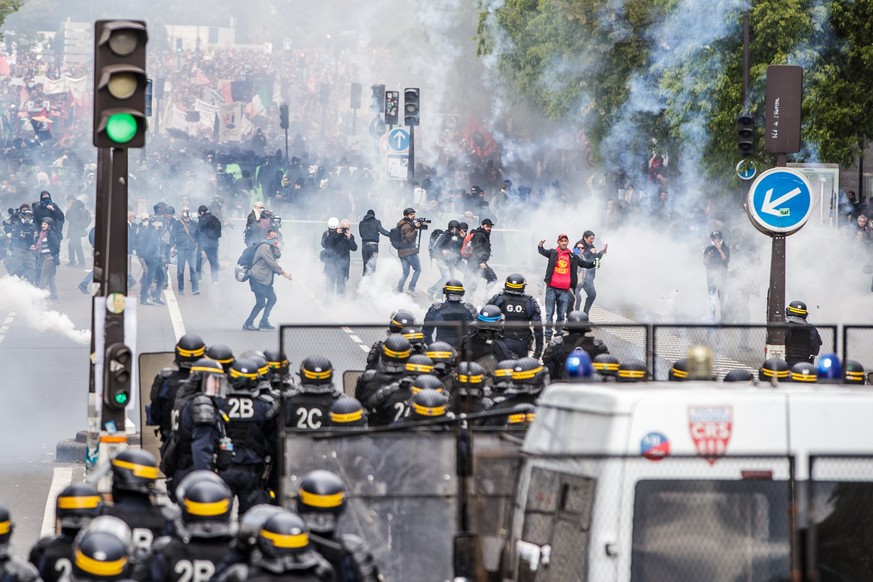 epa06705121 French riot police forces face young masked protesters during a demonstration of workers from the private and public sectors as well as labor unions on the occasion of the annual May Day m ...