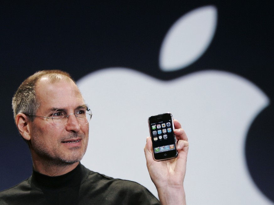 FILE- In this Jan. 9, 2007, file photo, Apple CEO Steve Jobs holds up an iPhone at the MacWorld Conference in San Francisco. Jobs introduced the first iPhone a decade ago. Jobs&#039; &quot;magical pro ...