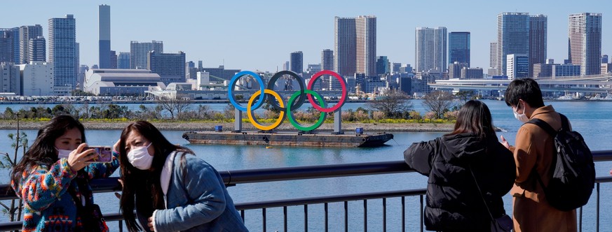 epa08273711 Visitors wearing masks take photos near the Olympic rings in Tokyo, Japan, 06 March 2020. According to Japan's Olympic Minister, the Coronavirus outbreak has forced several major even ...
