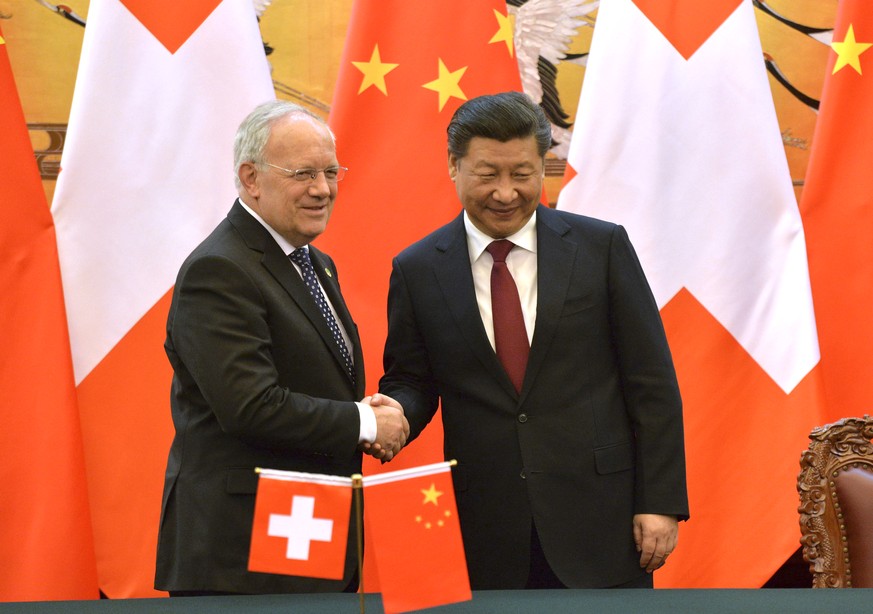 Switzerland&#039;s Federal President Johann Schneider-Ammann, left, and Chinese President Xi Jinping poses for photographers at the end of the signing ceremony at the Great Hall of the People in Beiji ...