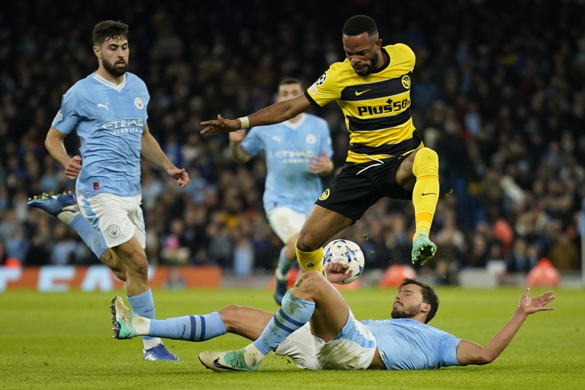 Young Boys' Meschak Elia, top right, is tackled by Manchester City's Ruben Dias during the group G Champions League soccer match between Manchester City and Young Boys at the Etihad Stadium  ...