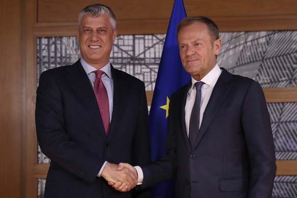 Kosovo&#039;s President Hashim Thaci, left, shakes hands for the media with European Council President Donald Tusk before their meeting at the European Council headquarters in Brussels, Monday, April  ...