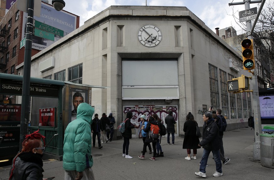 epa06606937 People are seen standing underneath a new street art work by Banksy, the anonymous British street artist is of a rat In the inner portion of a clock above a closed former bank building on  ...