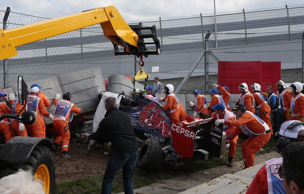 Course marshals remove the crashed car of Toro Rosso driver Carlos Sainz Jr. of Spain during the third free practice at the 'Sochi Autodrom' Formula One circuit in Sochi, Russia, on Saturday ...