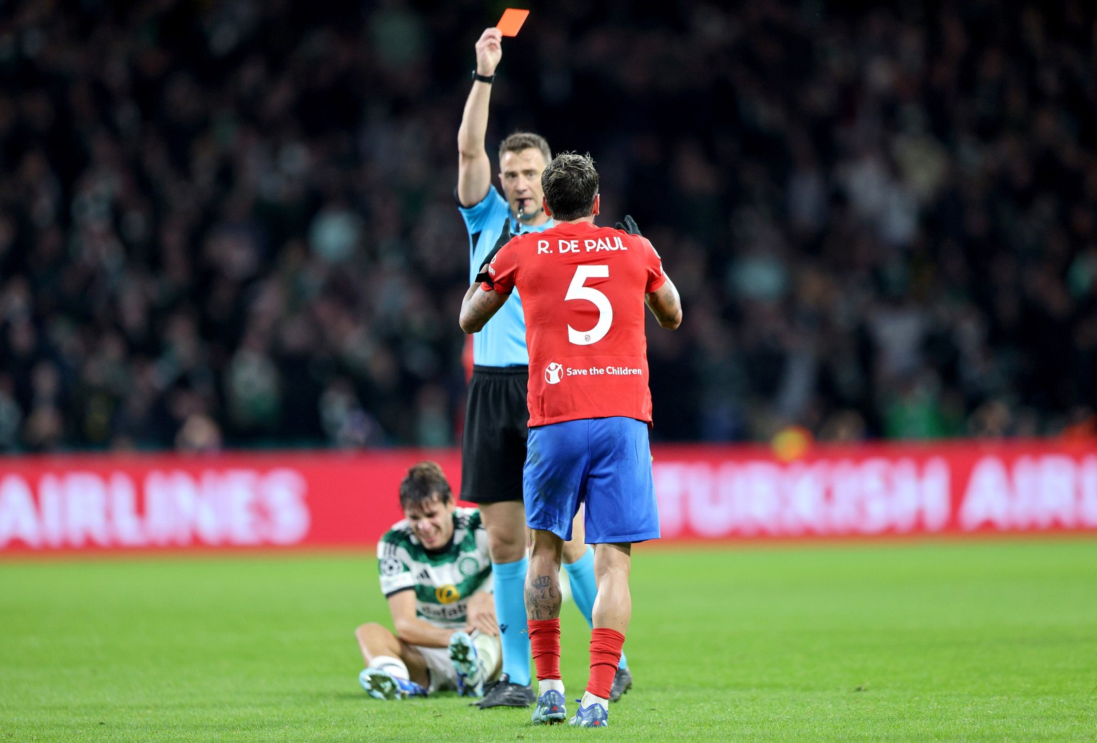 epa10939442 Rodrigo De Paul of Atletico is shown the red card by referee Felix Zwayer following his second yellow card during the UEFA Champions League Group E match between Celtic Glasgow and Atletic ...