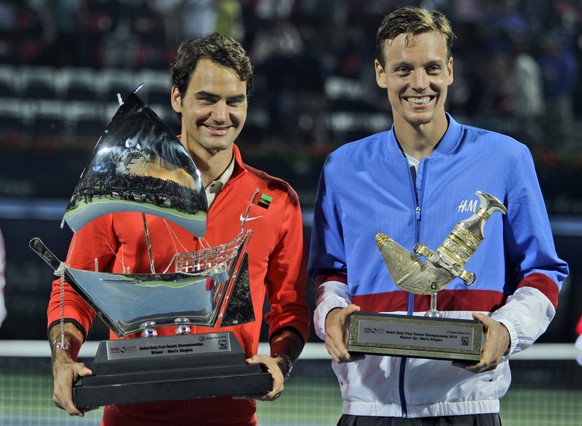 Roger Federer of Switzerland, left, and Tomas Berdych of Czech Republic display their trophies after Federer won the final match of the Dubai Duty Free Tennis Championships in Dubai, United Arab Emira ...