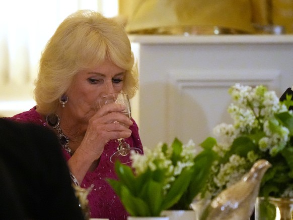 Britain's Queen Camilla take a sip from a glass as President Donald Trump speaks during a State Dinner with Britain's King Charles III and first lady Melania Trump in the East Room of the Wh ...