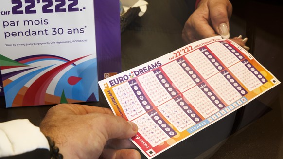 Un membre de la loterie romande presente le nouveau jeu de la loterie romande EURODRAMS a Josephine, kiosquiere, avant son lancement, ce lundi 16 octobre 2023 a Cheseaux-sur-Lausanne pres de Lausanne. ...