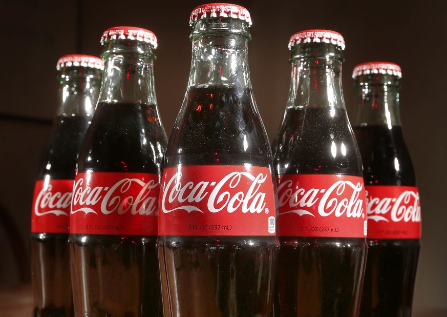 FILE- This April 28, 2016, file photo shows bottles of Coca-Cola in Concord, N.H. Coca-Cola may be getting into the booze business again by developing a bubbly alcoholic drink in Japan. The soda maker ...
