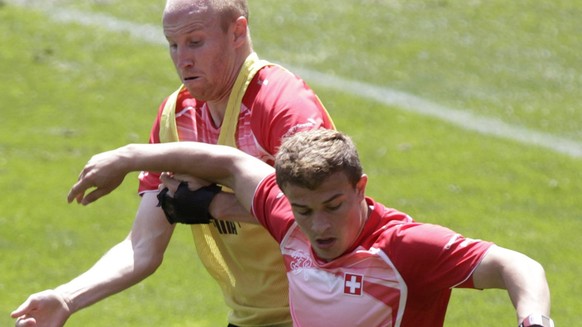 Swiss players Ludovic Magnin, left, fights for the ball with Xherdan Shaqiri, right, during a training session of Switzerland's national soccer team, at the stade de Geneve stadium, in Geneva, Sw ...