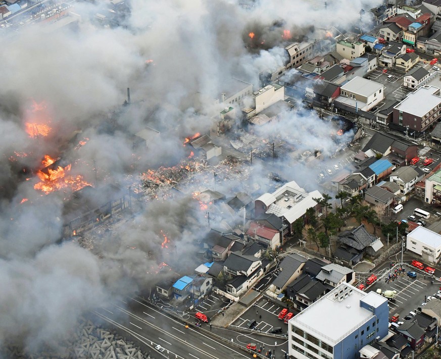 Smoke billow from houses during a fire in Itoigawa, northern Japan, Thursday, Dec. 22, 2016. A fire whipped by high winds has spread to at least 140 buildings in a small Japanese city on the Japan Sea ...