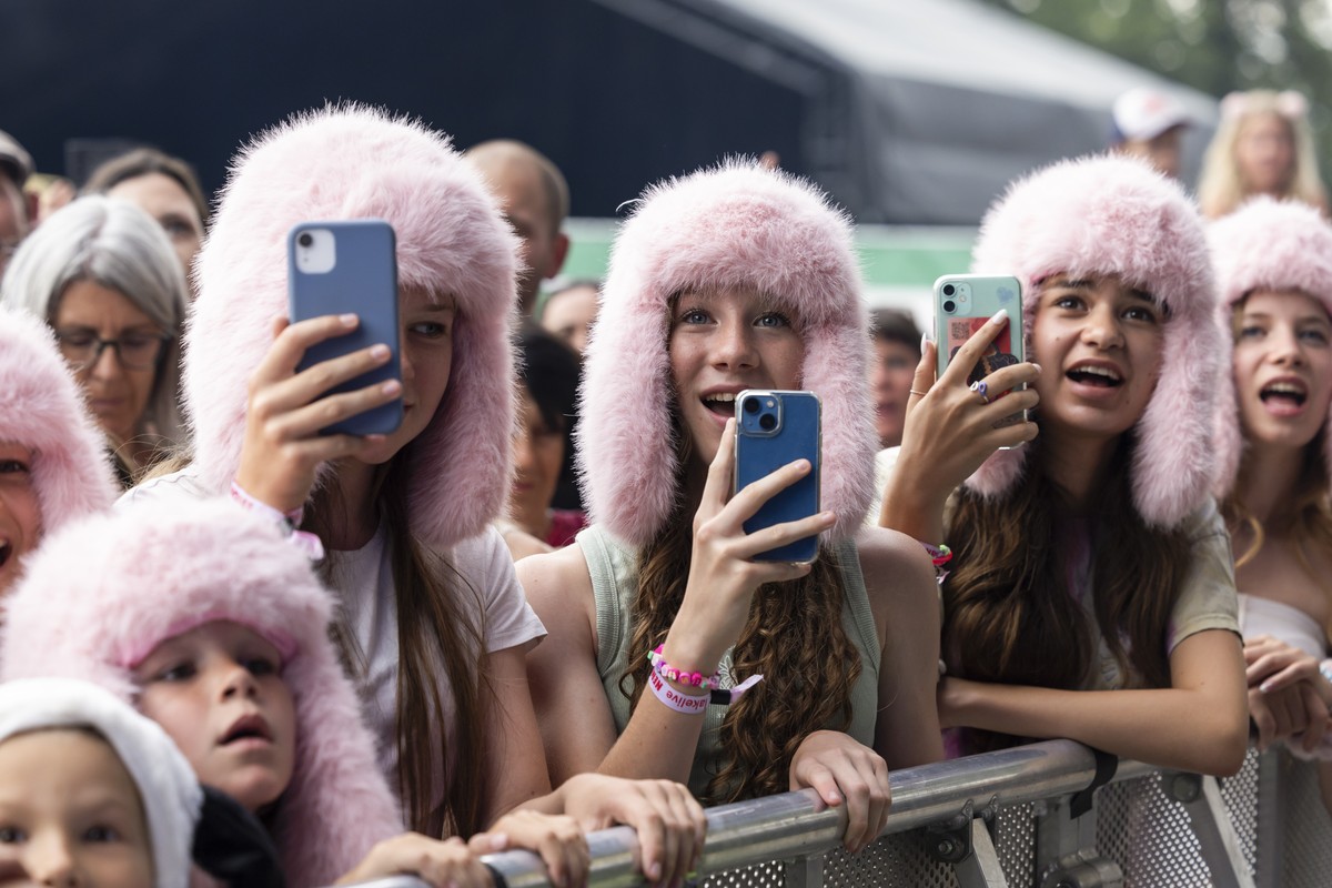 epa11513221 Festival-goers watch as Swiss singer and 2024 Eurovision Song Contest winner Nemo (not pictured) performs at the Lakelive Festival in Biel, Switzerland, 31 July 2024. EPA/PETER KLAUNZER ED ...